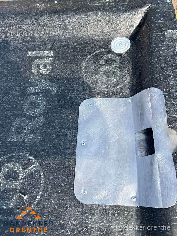 Dakdoorvoer met metalen afvoerplaat op bitumen dak in Drenthe