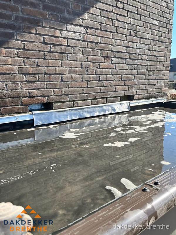 Stilstaand water op plat dak door slechte afwatering in Drenthe Stilstaand water op plat dak door slechte afwatering in Drenthe