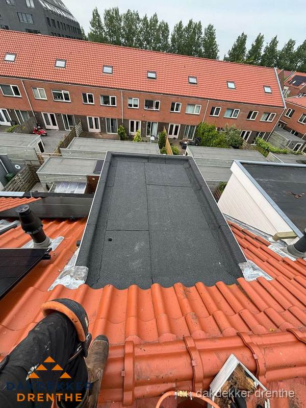 Bitumen dak reparatie op plat dak tussen dakpannen in Drenthe