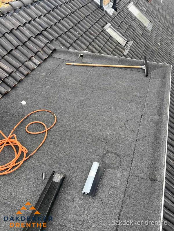 Plat dak reparatie met gereedschap en loodstroken in Drenthe