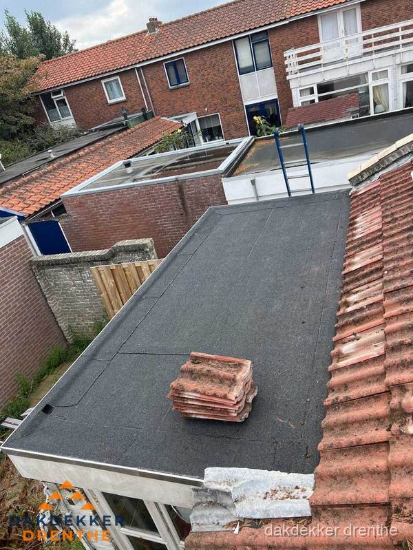 Plat dak aanbouw met bitumen naast schuin pannendak in Drenthe