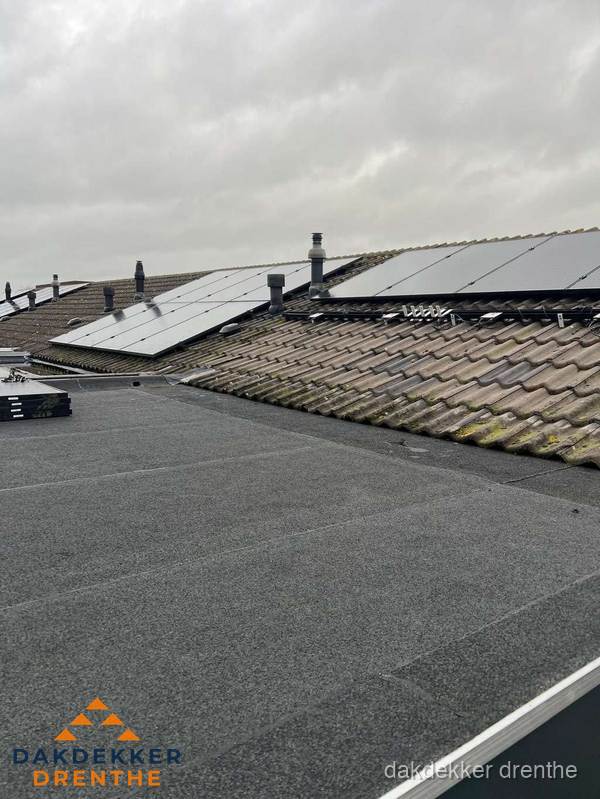 Bitumen dakbedekking op plat dak met aansluitend pannendak en zonnepanelen in Drenthe
