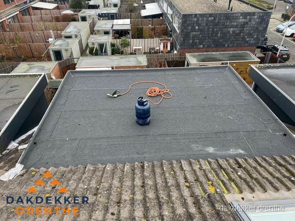 Plat dak met nieuwe bitumen dakbedekking en brandgereedschap in Drenthe